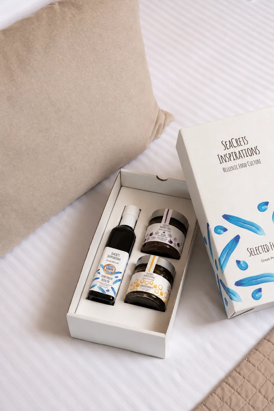 SeaCrets welcome gift box with olive oil, honey and fig preserve on a hotel bed